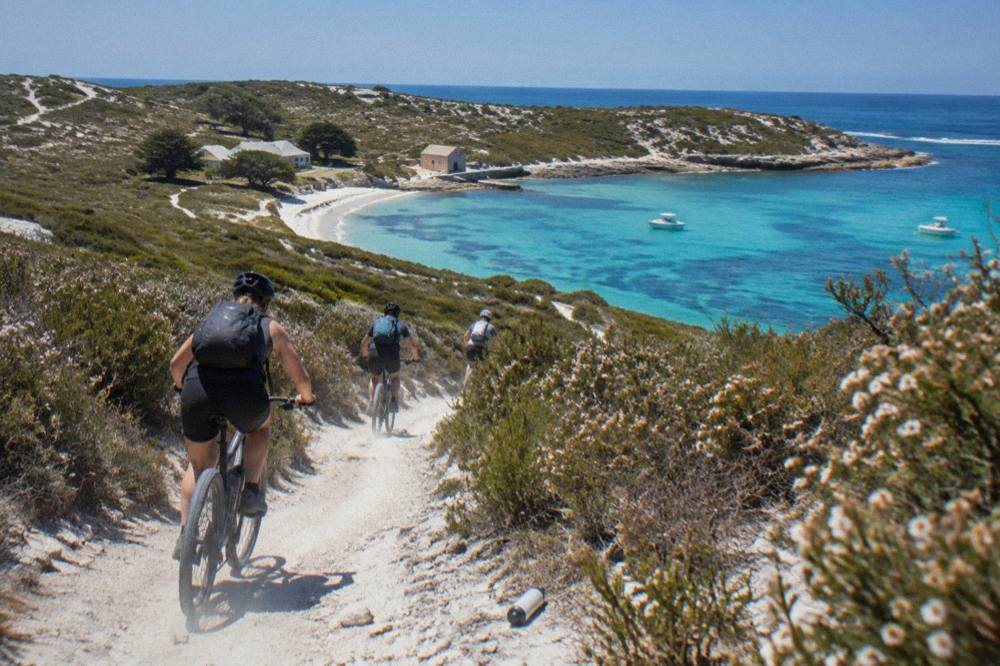 Cyclists on a coastal path above a sheltered bay at Rottnest Island