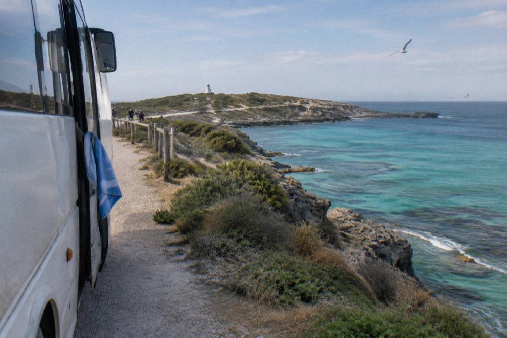 A guided tour bus stopped at a lookout above the sea on the western end of Rottnest Island