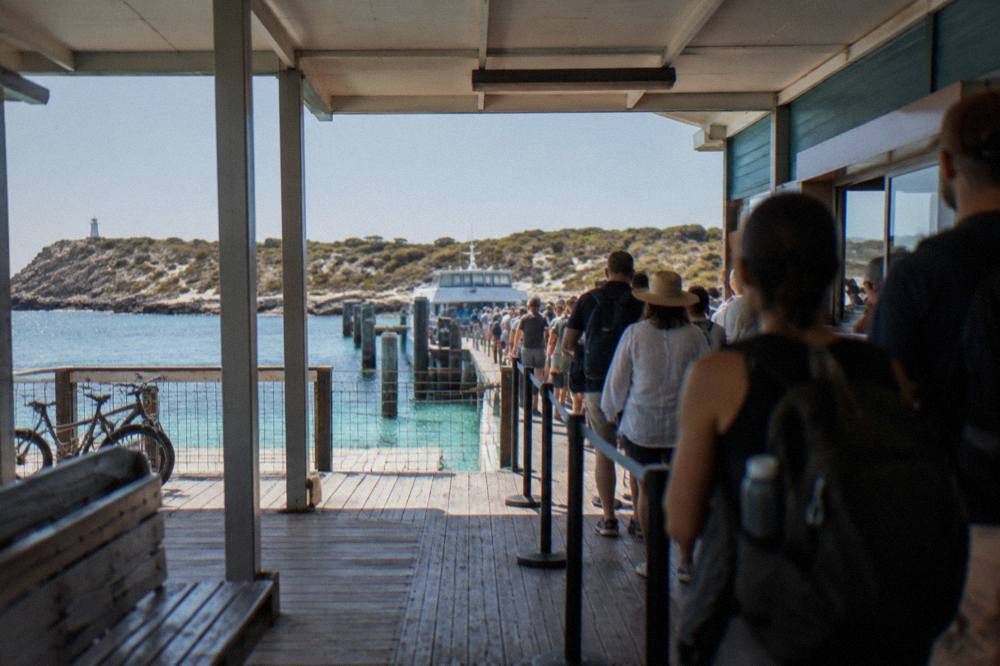 A ferry ticket counter at a wharf with passengers waiting to board