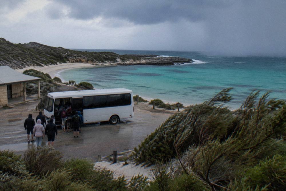 A hop-on hop-off island bus at a stop near the Thomson Bay settlement