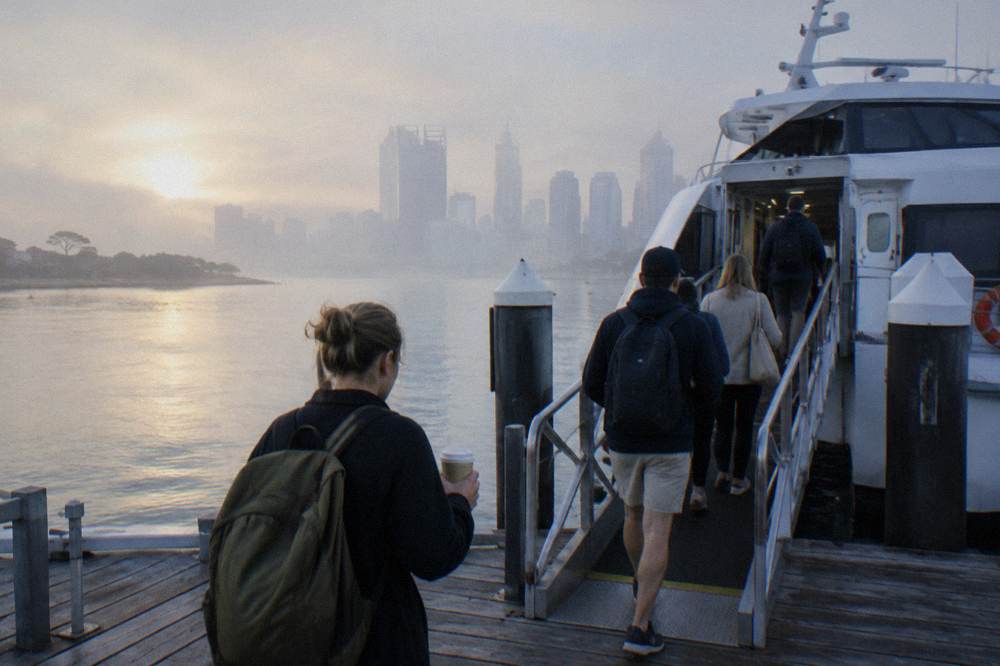 Passengers boarding a ferry at a Perth jetty in morning light