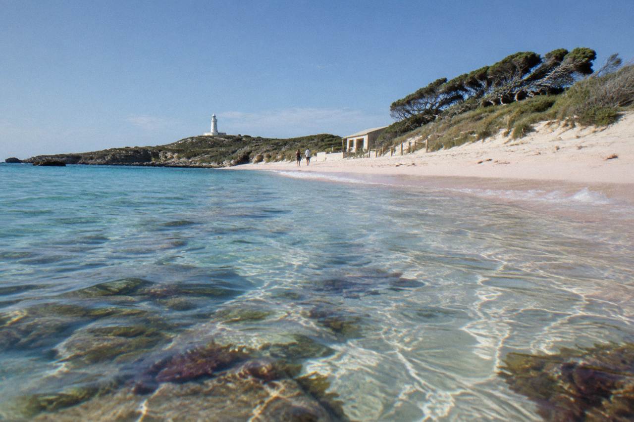 Turquoise shallow water over a sandy bay at Rottnest Island with reef visible below the surface