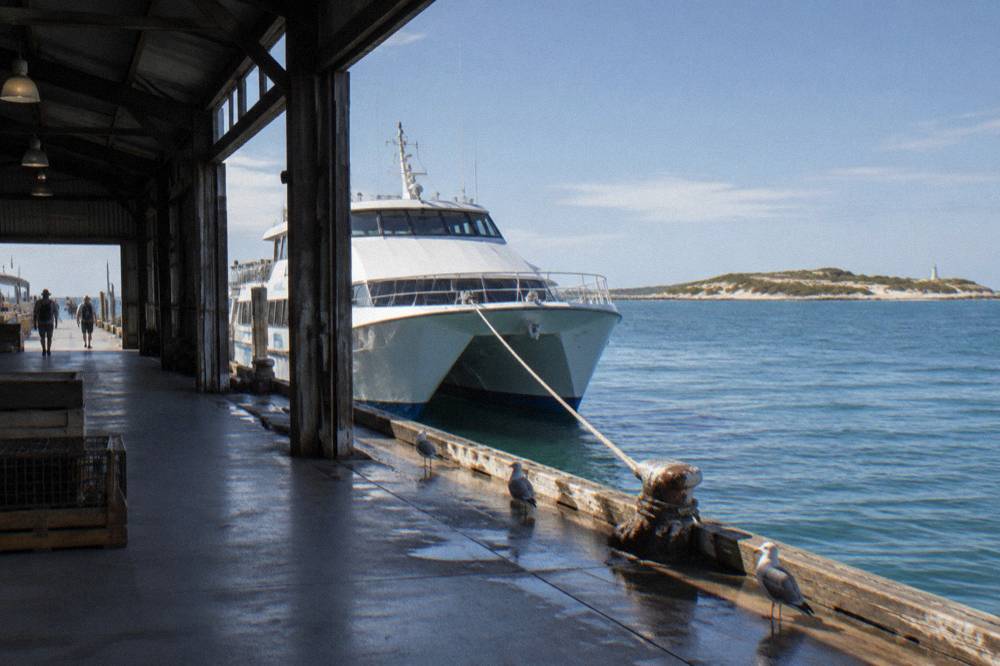 A ferry terminal jetty on a clear morning with a passenger ferry tied up at the berth