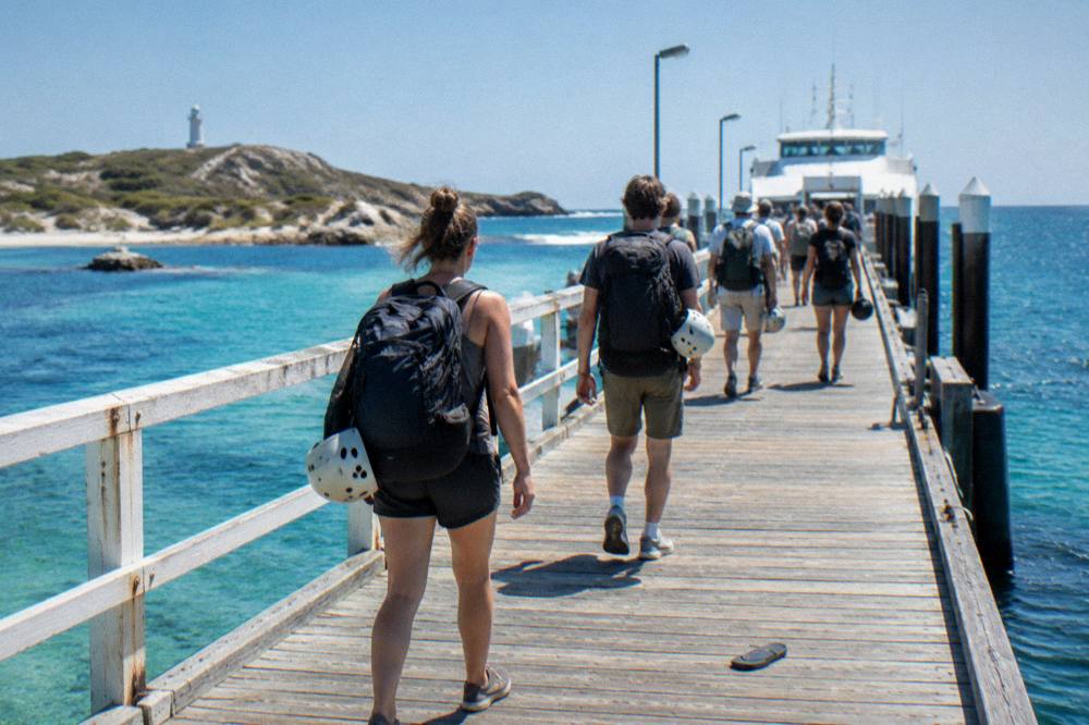 Ferry passengers with bikes walking down the main jetty at Rottnest Island