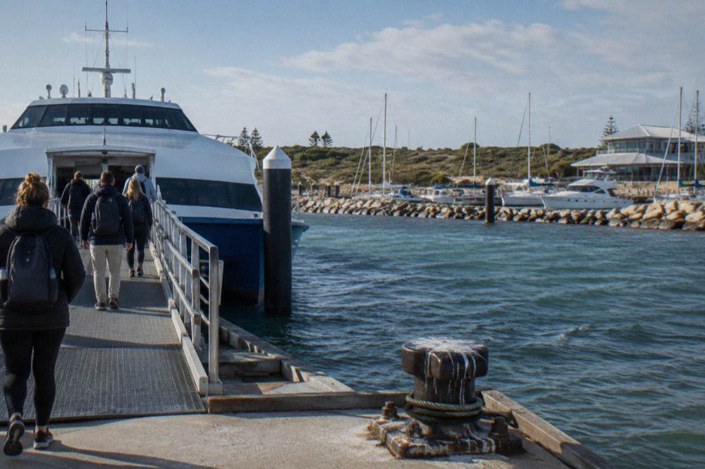 Ferry terminal at Hillarys Boat Harbour with boarding passengers and moored boats