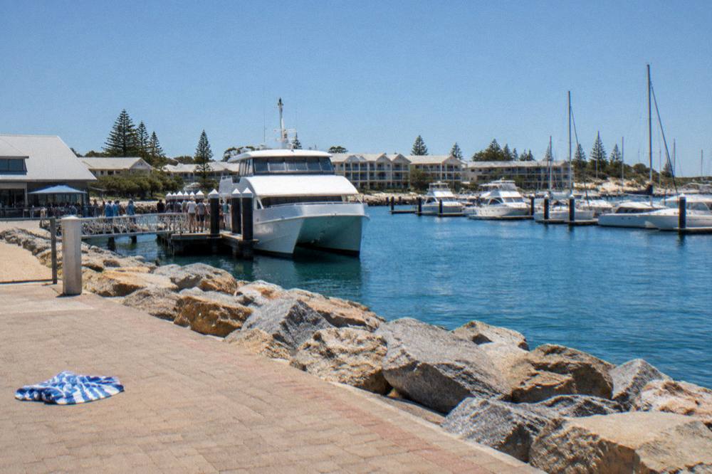 Busy jetty with a ferry and passengers boarding on a bright summer day