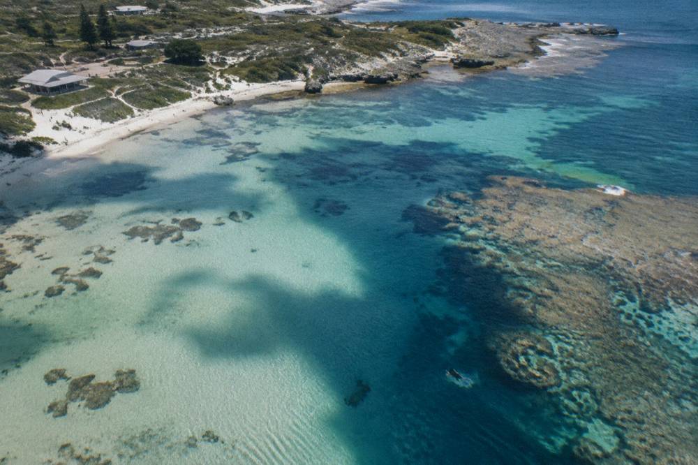 Cloud shadows moving across turquoise water and pale reef