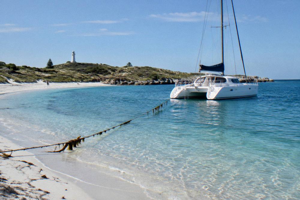 A sailing catamaran moored in a clear blue bay at Rottnest Island