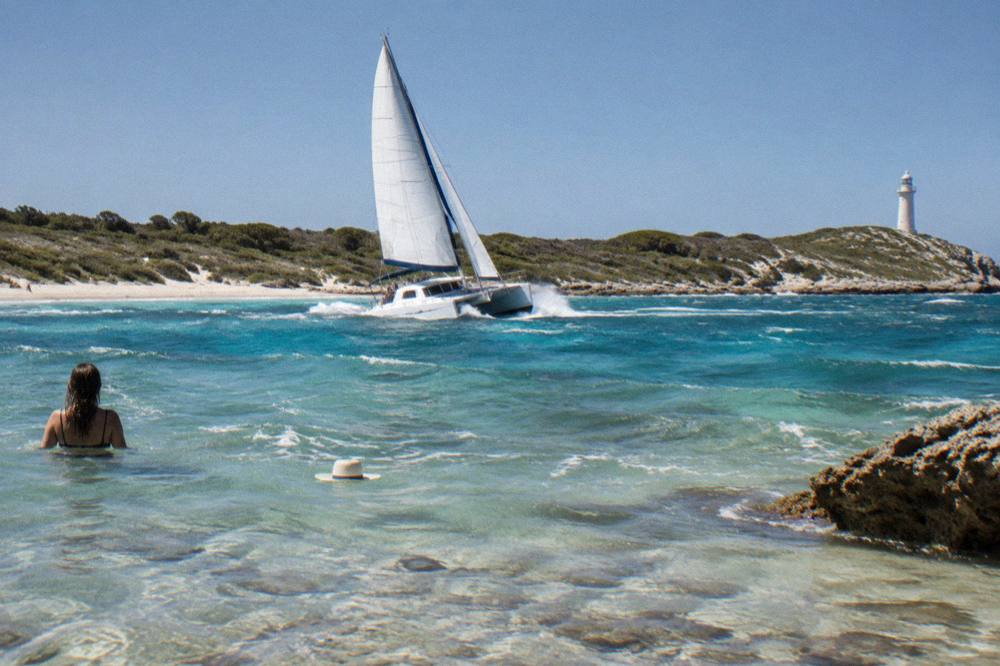 Sailing catamaran on clear turquoise water near Rottnest Island